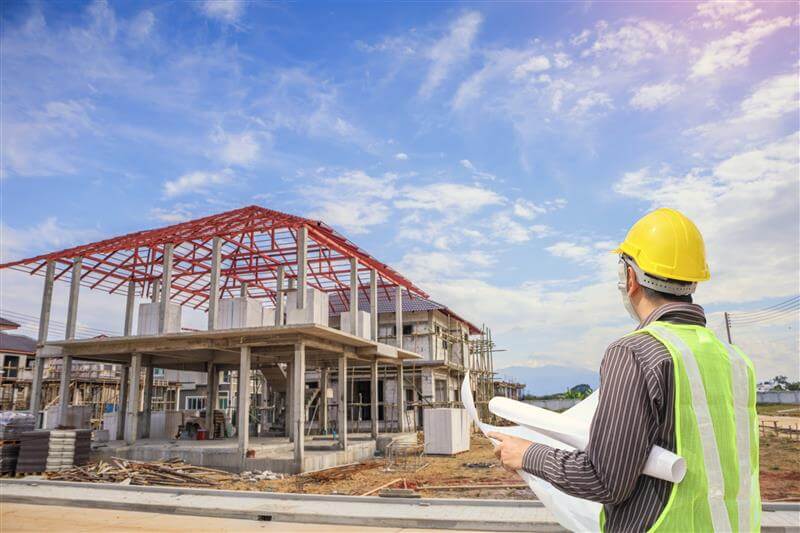 professional-engineer-architect-worker-with-protective-helmet-blueprints-paper-house-building-construction-site-background
